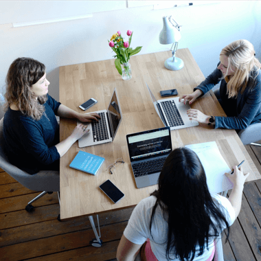 An image of a diverse group of employees engaged in a lively discussion around a conference table, with laptops and documents spread out. Caption: "Collaborative Excellence: Our dedicated team of professionals working together to deliver top-notch services, fostering innovation and success through dynamic collaboration.